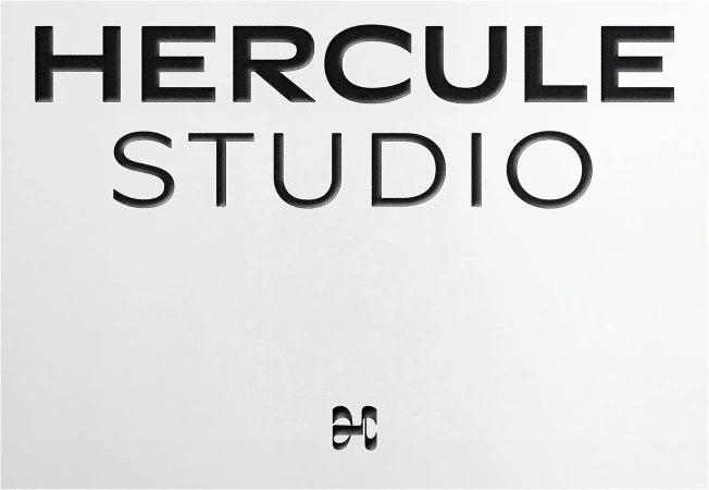 Embossed black typography reading Hercule Studio on a clean white paper background with a small monogram mark.