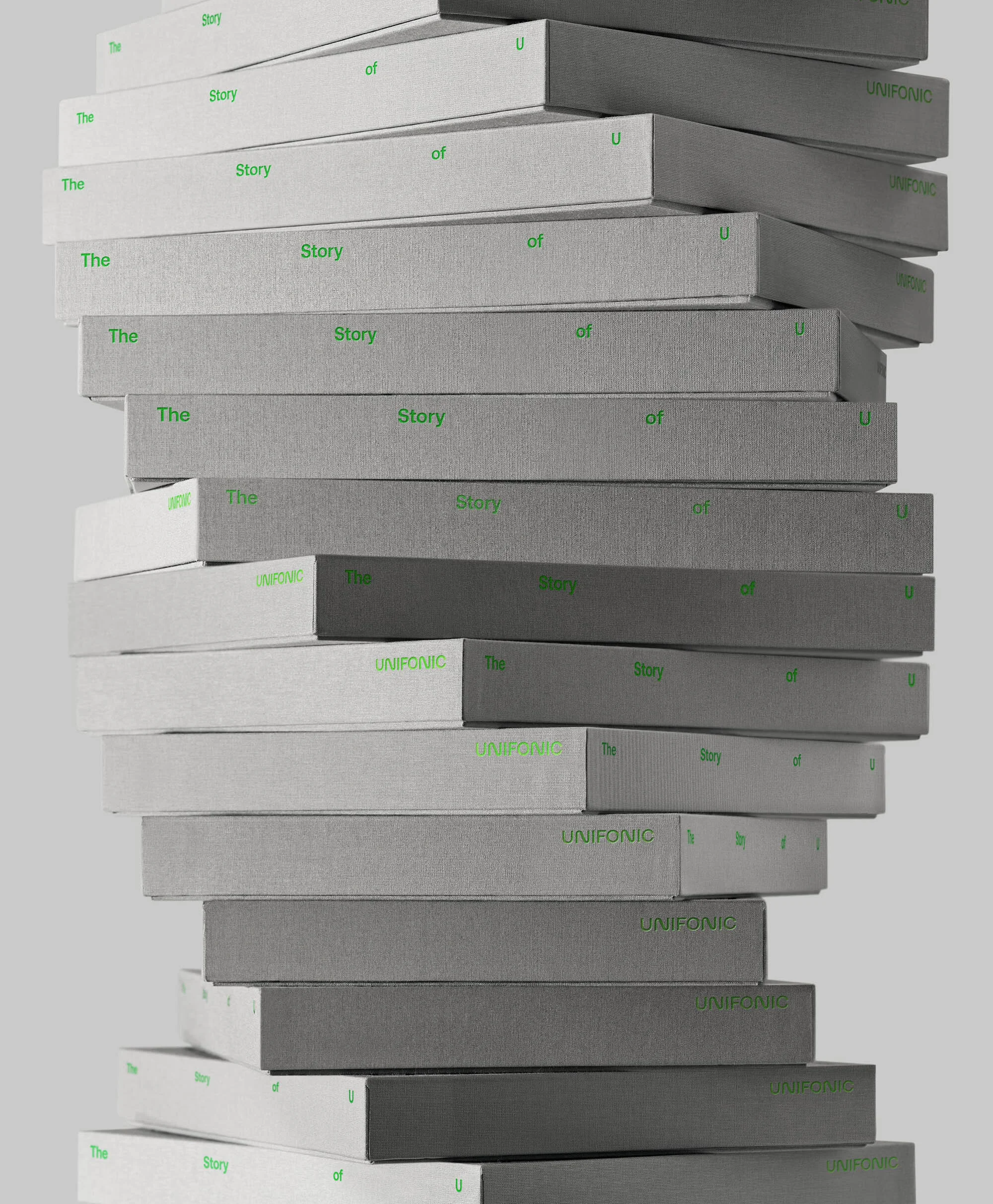 Stack of gray and white boxes with green text reading 'The Story of' and 'UNIFONIC' against a light gray background.