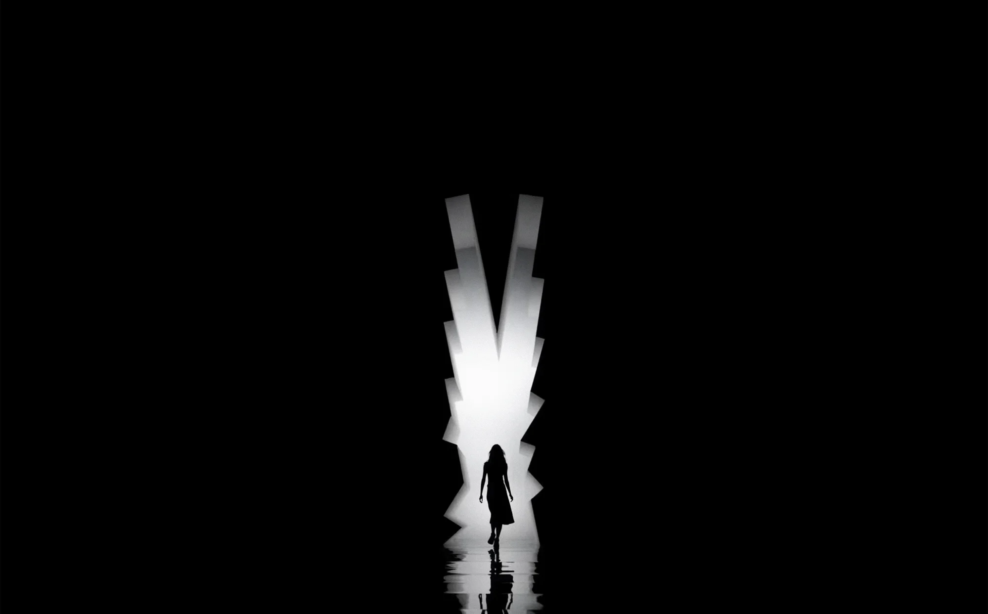 Silhouette of woman walking through a bright light against a dark background. Person in motion, fashion or conceptual photography.
