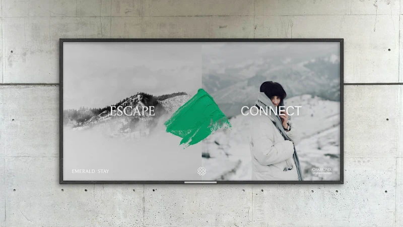 Poster on concrete wall featuring mountain landscape, green paint stroke, and woman in winter apparel for Emerald Stay Chamonix.