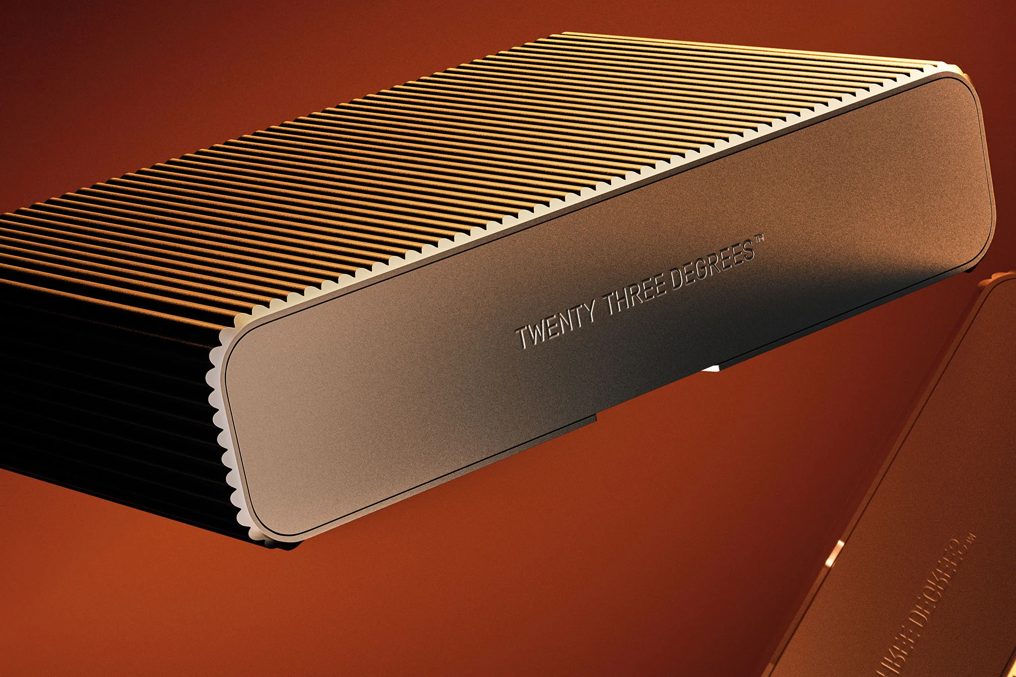 Close-up of an elongated bronze rectangular device with ridged top, featuring the text 'TWENTY THREE DEGREES' against an umber background.