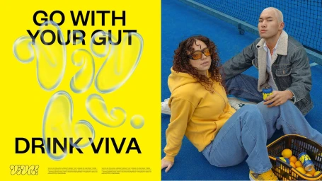Split view with yellow graphic background on left and two young adults seated on blue court on right holding branded cans