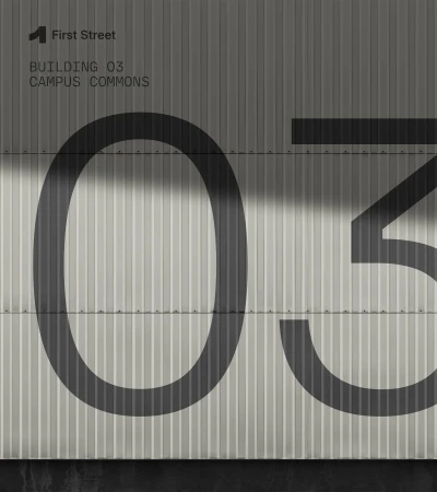 Exterior building wall with architectural signage, featuring large painted numbers and text for 'First Street' and 'Campus Commons'.