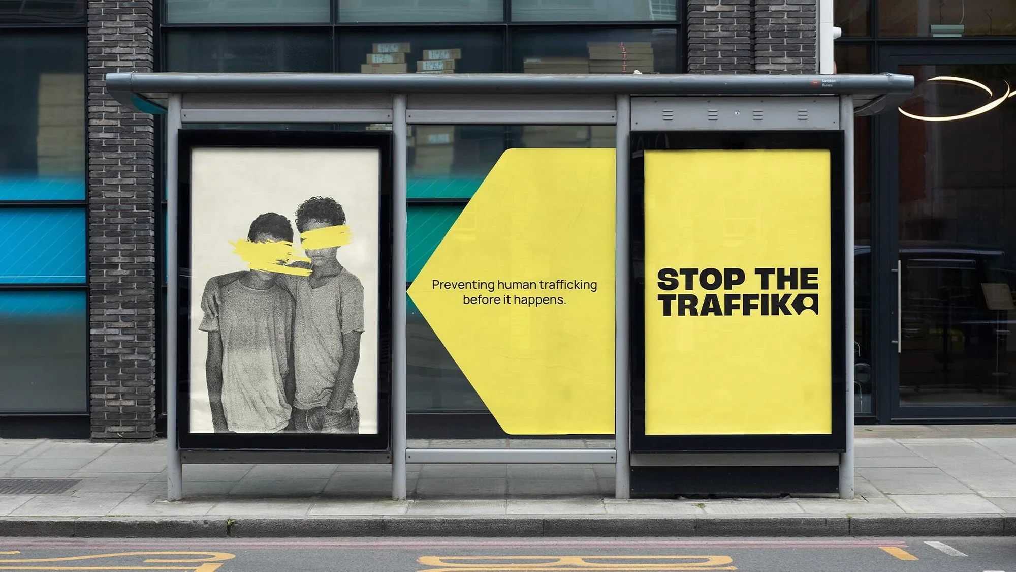 Bus stop advertisement featuring two young people with their eyes covered and text "Stop the Traffik" to raise awareness of human trafficking.
