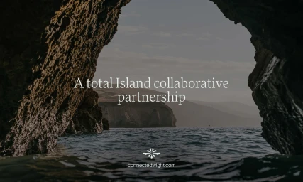 View of the ocean through a rocky coastal cave opening with distant cliffs and typography overlay for Connected Wight brand identity