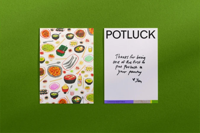 Two greeting cards on a green surface: one with illustrated food, the other with a handwritten message and the word 'POTLUCK'.