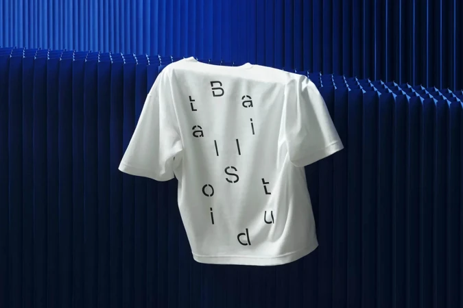 Studio shot of a white Balistuid t-shirt against a blue corrugated background, showcasing a minimalist fashion aesthetic.