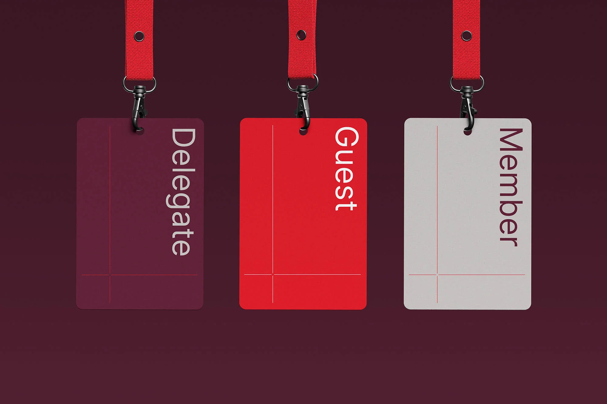 Three colorful name tags hanging from red lanyards against a maroon background. Each name tag has a different title: Delegate, Guest, Member.