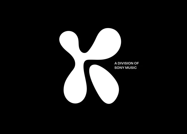 Abstract white K-shaped logo graphic with 'A DIVISION OF SONY MUSIC' text on a solid black background, minimalist design.