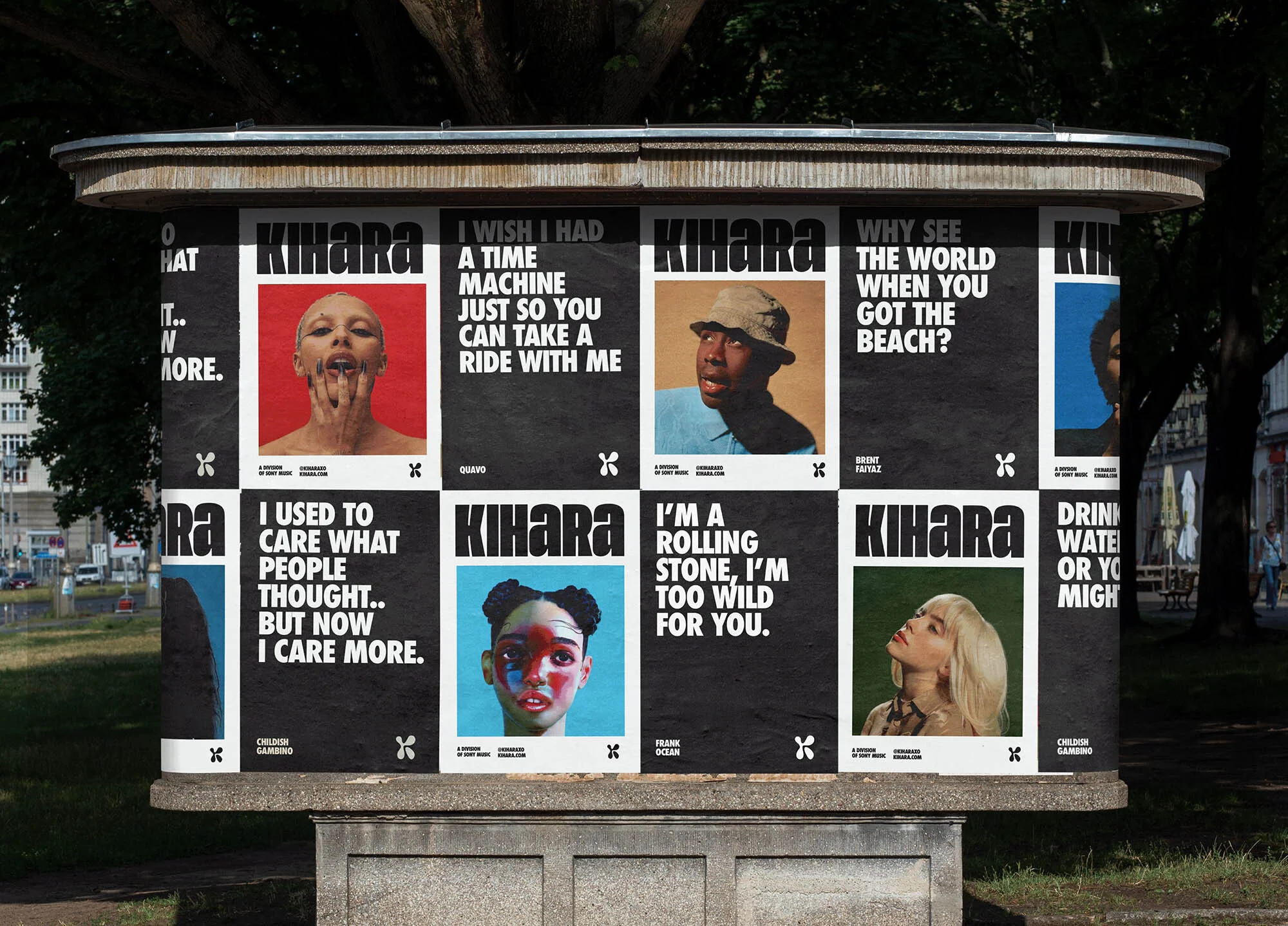 Outdoor shot of a bus stop shelter with eight KiHaRa posters featuring portraits and song lyrics, including 'I Wish I Had A Time Machine'.