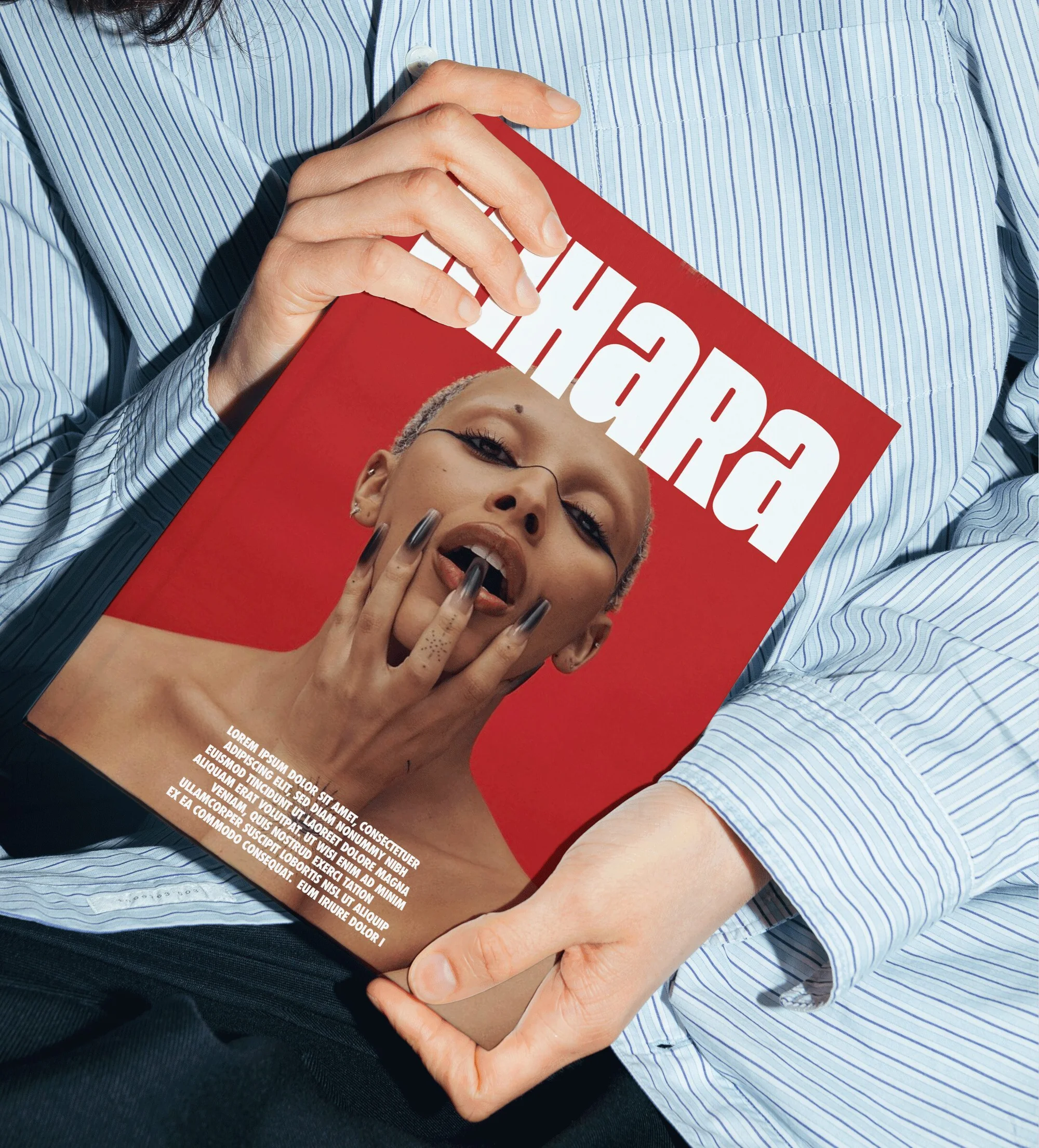 Person holding a magazine with a model on the cover in a studio setting, featuring a red background and bold white title.