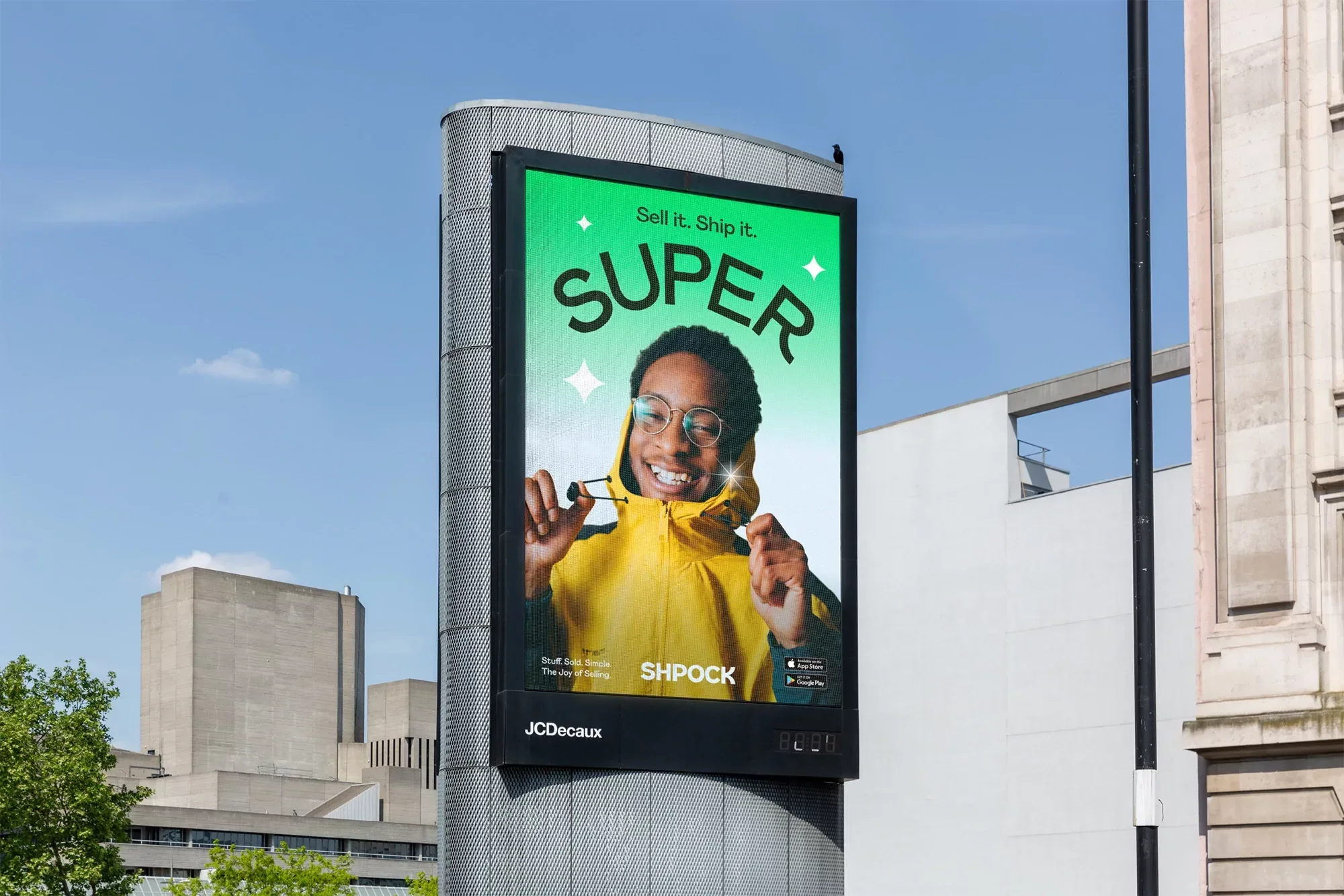 Billboard ad features a smiling African American man in a yellow hoodie, advertising SHPOCK, against a blue sky and city buildings.