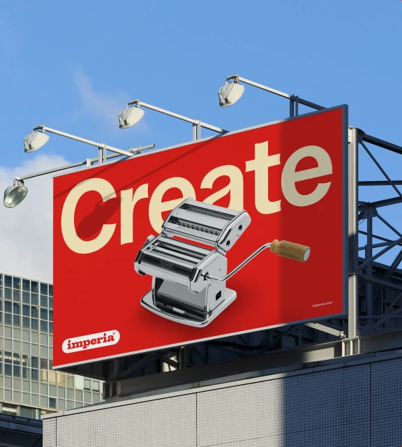 Billboard with Imperia pasta maker advertisement against a blue sky and urban background, featuring the word 'Create' in cream color.