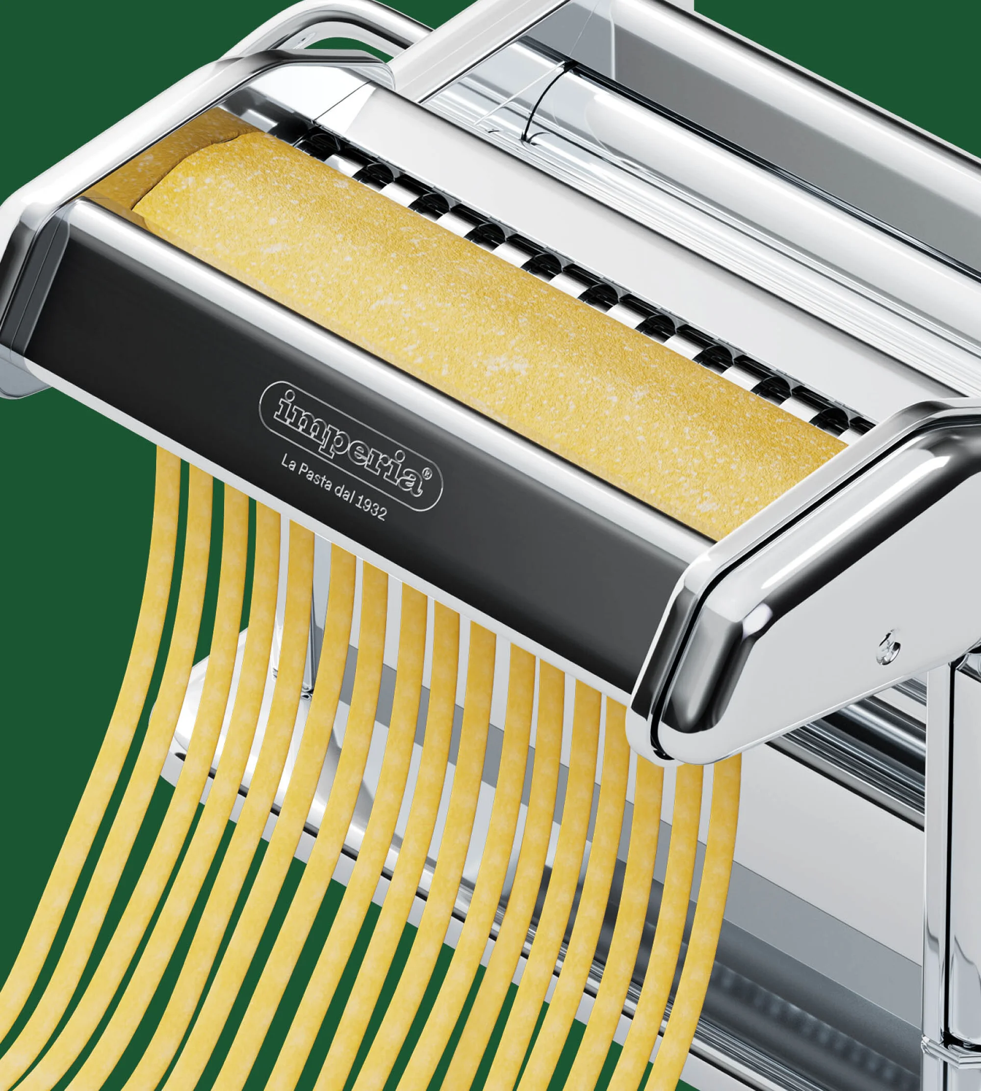Close-up of a silver Imperia pasta machine creating fresh spaghetti strands on a green backdrop, showcasing kitchen culinary equipment.