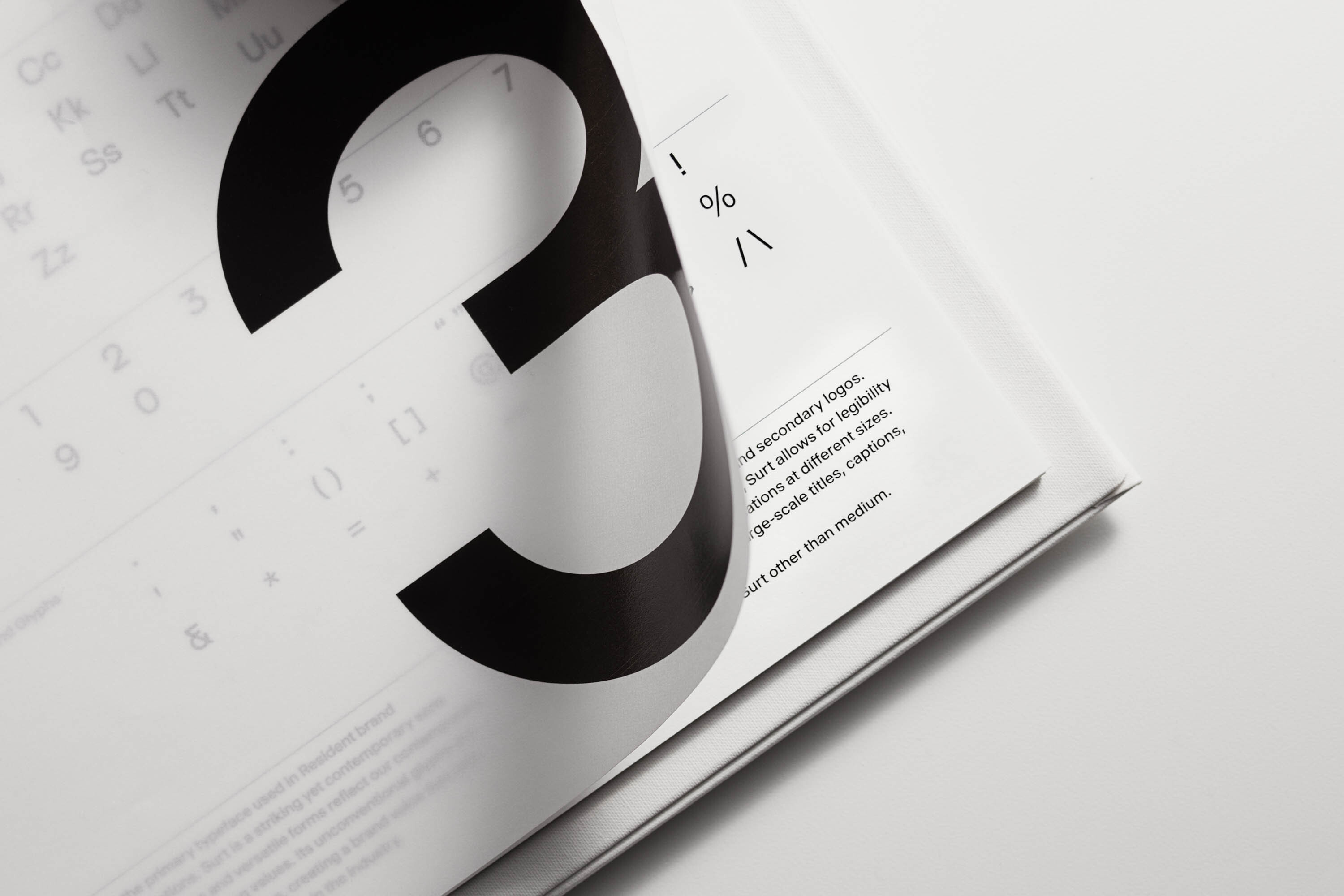 Open book on a white surface featuring a large black number '3' and smaller text, focused on typography and graphic design elements.