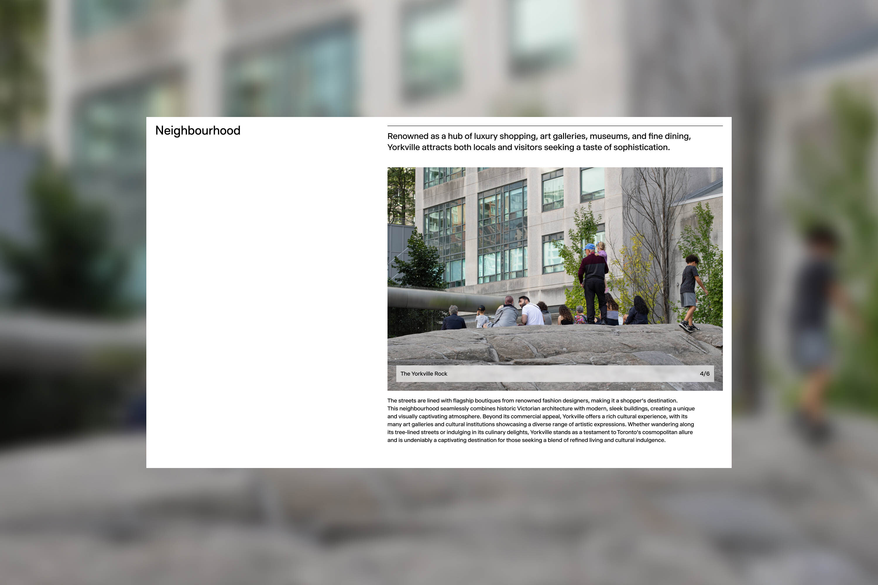 Outdoor scene featuring a group of people relaxing on a rock formation in an urban environment, with modern architecture in the background.