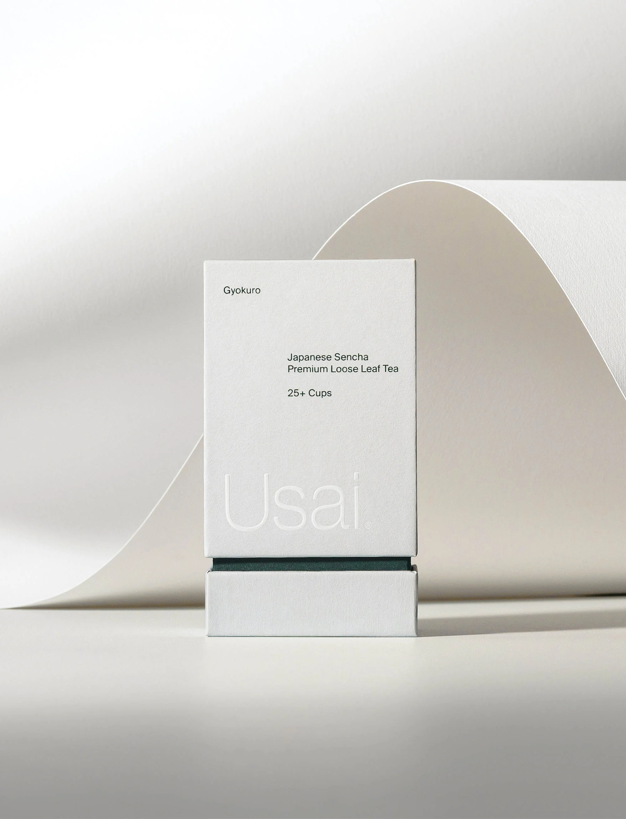 Product shot of a white tea box with minimalist design featuring the brand name Usai, set against a soft, neutral background.