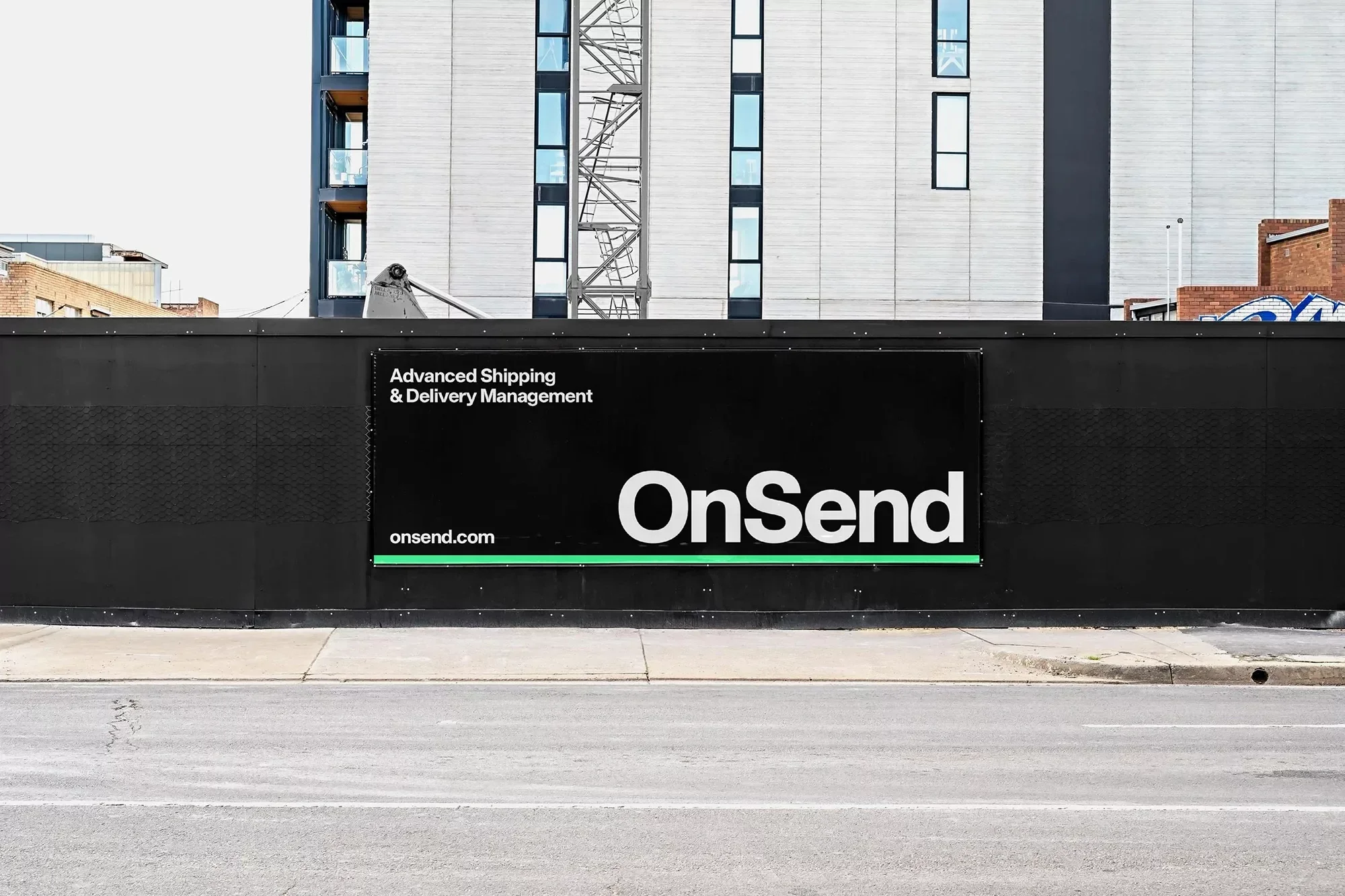 Building exterior featuring a black fence with the OnSend company logo and signage with white text and a green accent line.