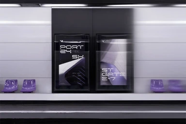 Subway station platform featuring two large advertising posters with dark and purple graphics mounted on a black pillar between white wall panels.
