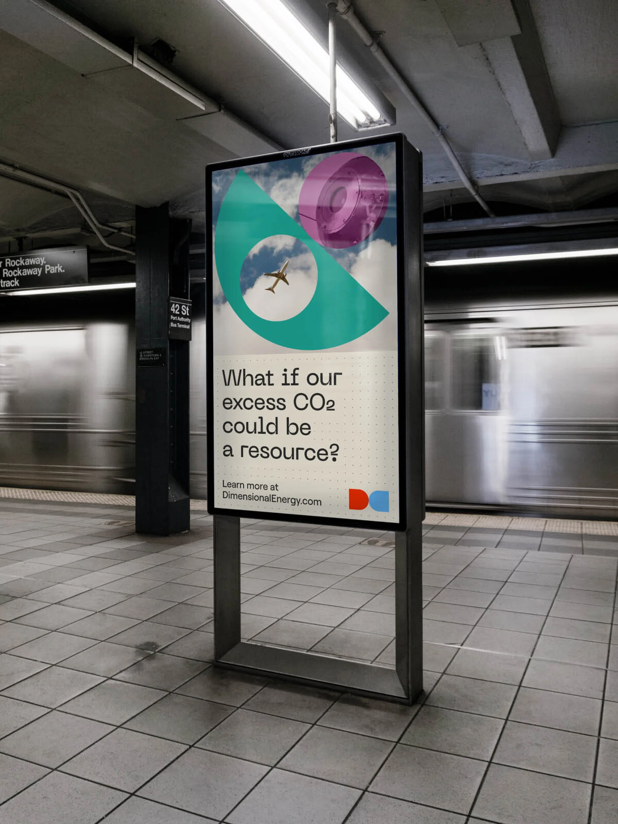 Advertising poster in a subway station features abstract graphic and the question 'What if our excess CO2 could be a resource?'