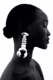Black and white profile portrait of a woman wearing a large, textured silver earring for H&M.