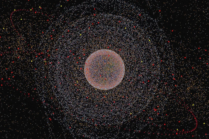 Digital graphic artwork displaying a central spherical cluster surrounded by concentric orbits of particles and dots on a dark background.