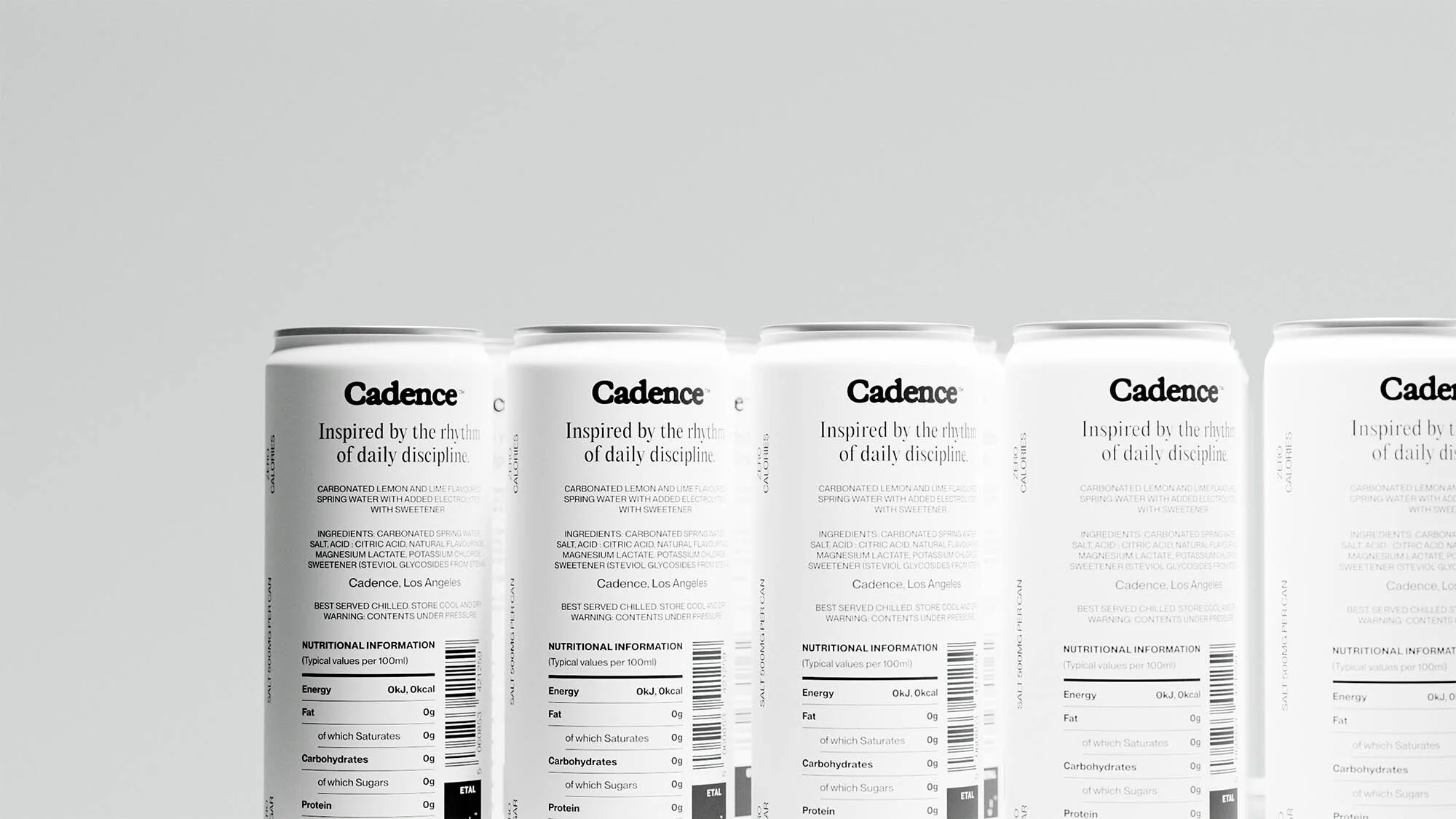 Multiple white cans of Cadence brand carbonated lemon and lime flavored spring water are lined up against a white background in a studio shot.