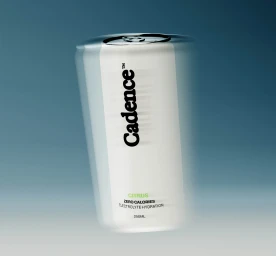 A white beverage can with Cadence branding centered against a smooth blue gradient background with motion blur effect