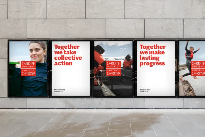 Posters on a light grey tiled wall show active people and the Cardiff University logo, advertising “Together we take collective action”.