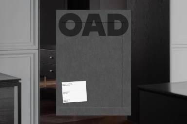 Grey paper envelope featuring bold OAD typography and a white label set against a dark interior background.