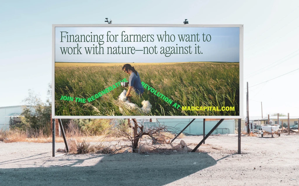 Billboard advertisement featuring a woman working in a field, promoting financing for farmers in harmony with nature at MADCAPITAL.com.