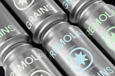 Close-up angled shot of metallic beverage cans featuring Premolar Grains branding and light-coloured typography against a dark background