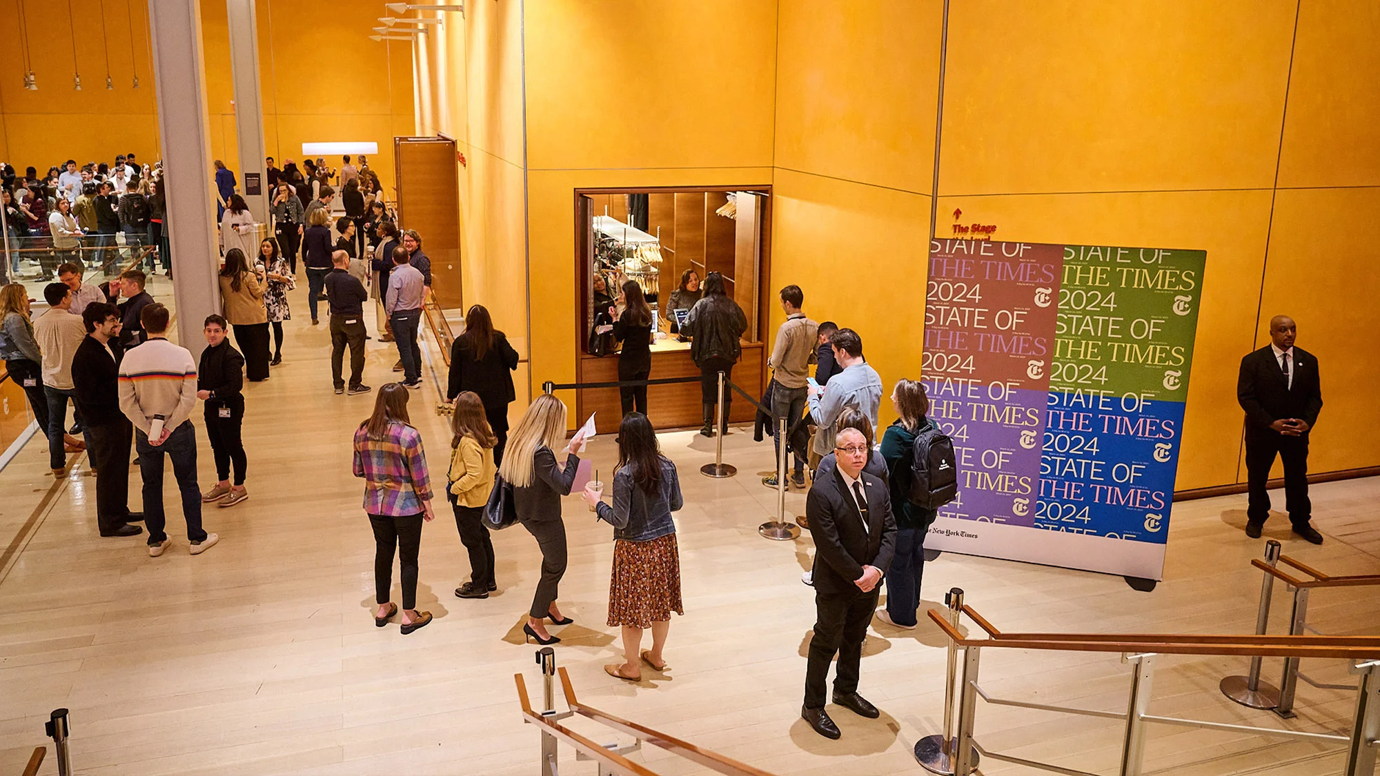 Large crowd of people inside a building, with a ticket booth and signage for 'State of the Times 2024'.