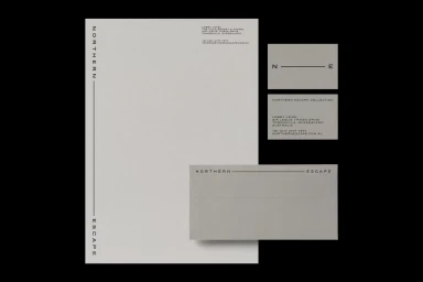 Stationery items including letterhead, business cards, and envelope featuring minimalist typography on a grey background.