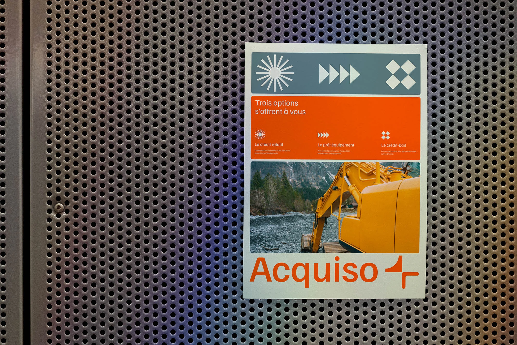 Advertisement featuring a yellow excavator against a mountain backdrop, with a gray perforated metal sheet as the background texture.