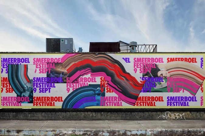 Outdoor view of a large mural ad for the Smeerboel Festival, featuring colorful abstract graphics and event information on a concrete wall.