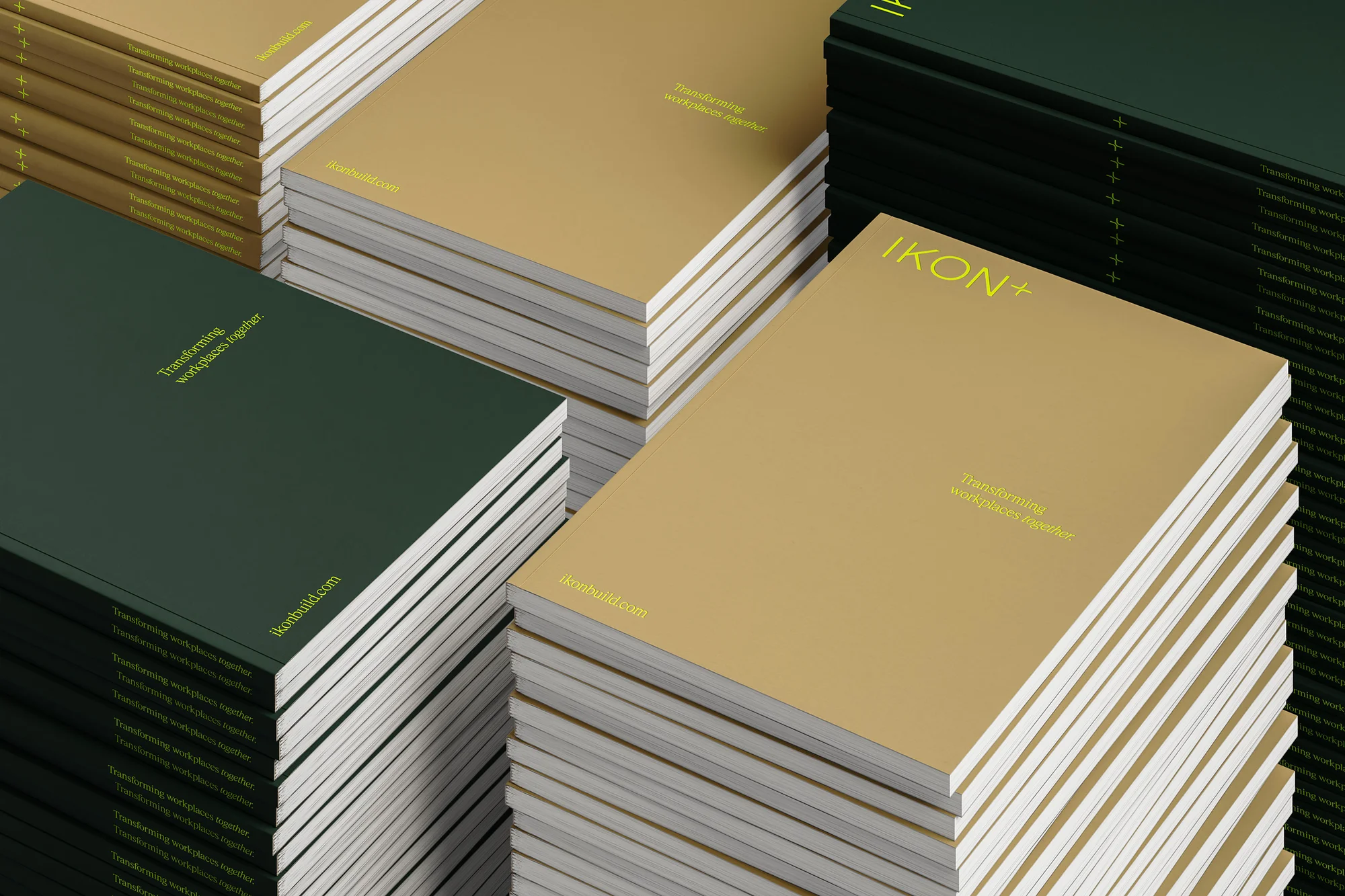 Stacked stacks of tan and dark green corporate brochures with minimalist yellow typography on a clean surface