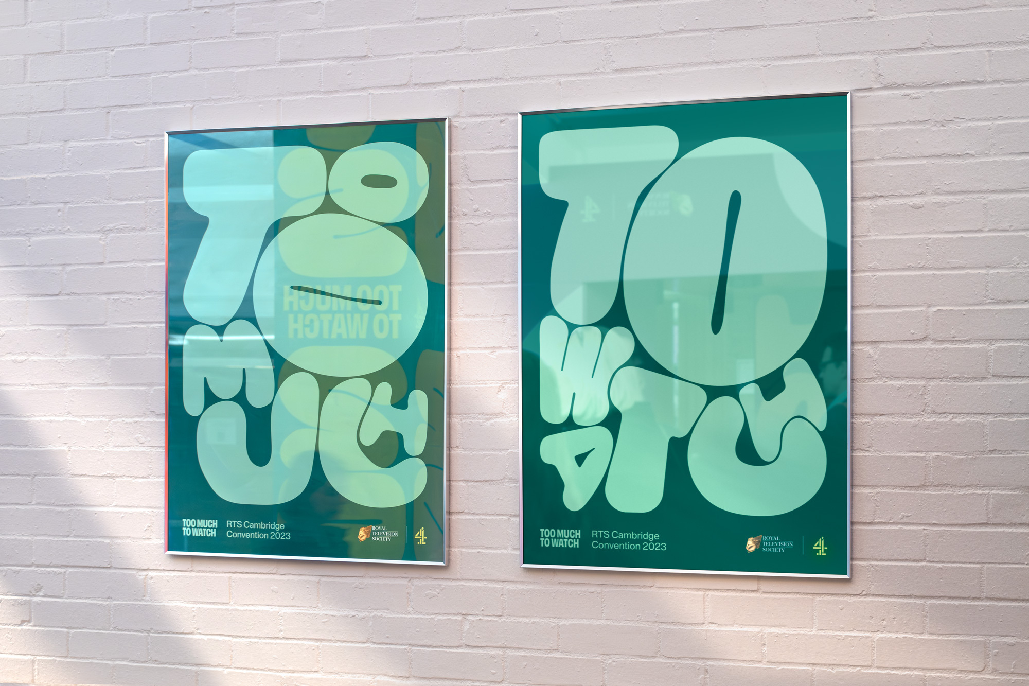 Two framed posters on a white brick wall, featuring bubble-lettered graphics with a color palette of teal, green and white.
