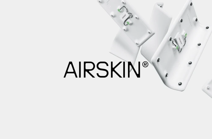 Product shot showcasing AIRSKIN® technology with white components and visible circuitry against a neutral backdrop with brand typography.
