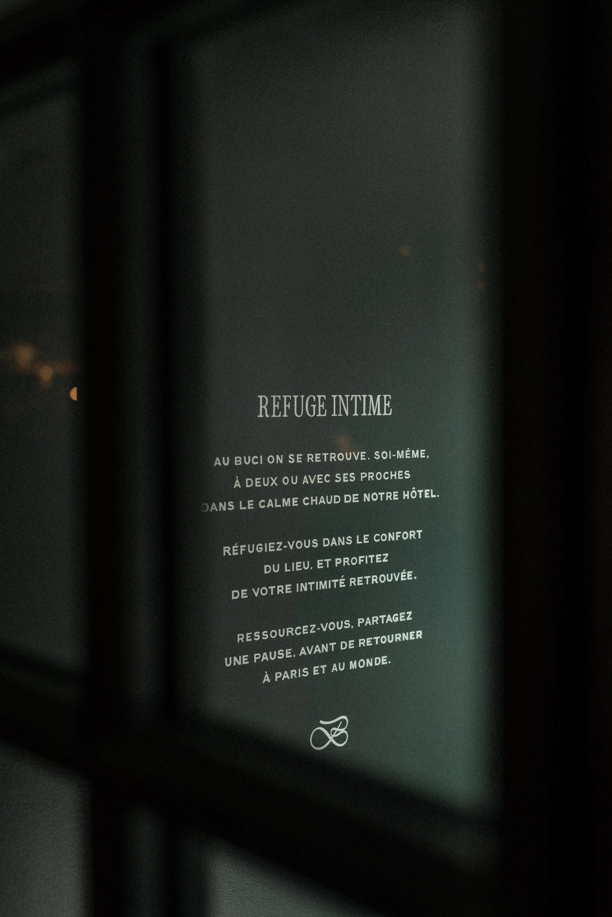 Window display with text in French advertising Refuge Intime, promoting a calming retreat in a hotel, Paris, France.