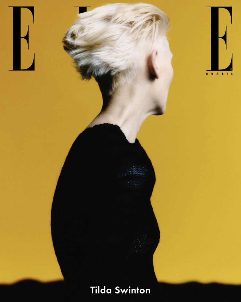 Elle Brasil cover featuring Tilda Swinton in black top against a golden yellow background, magazine logo visible at the top.