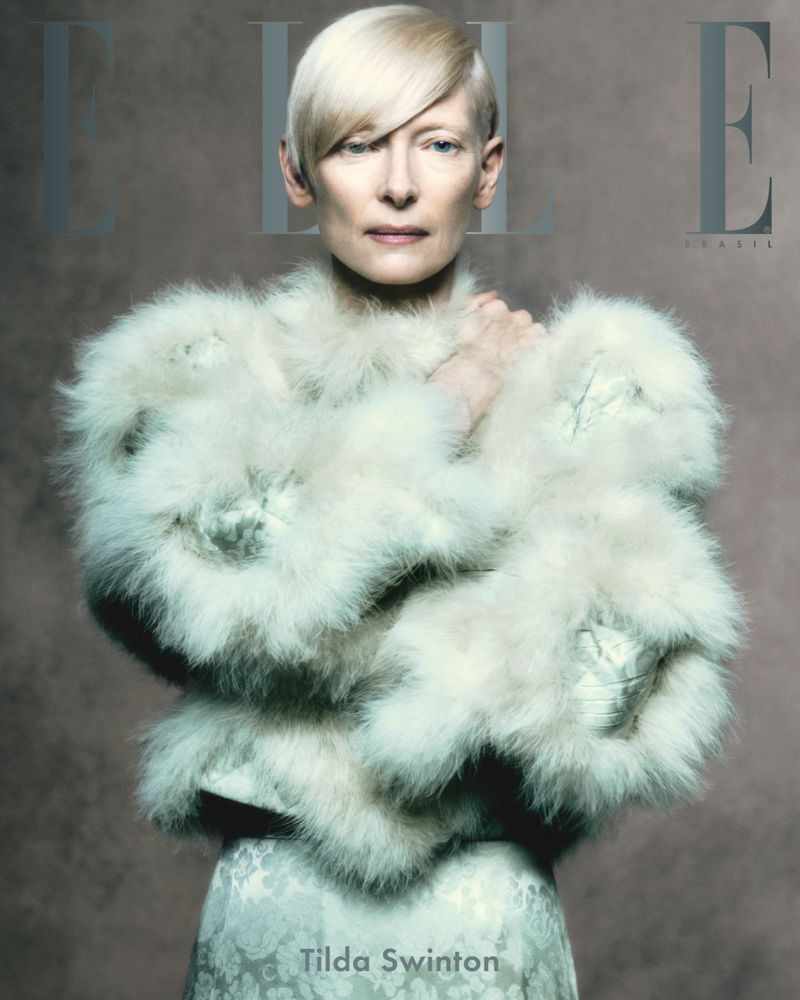 Fashion editorial cover featuring Tilda Swinton wearing a large fluffy white coat. Magazine cover has ELLE logo.