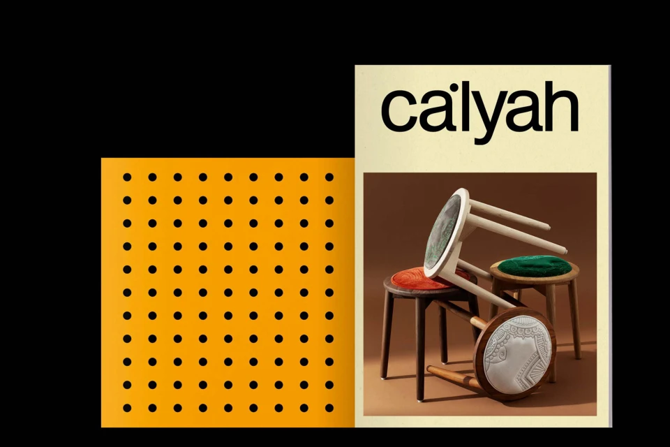 Still life of stacked decorative stools, displayed on a tan background next to a yellow pattern block against a black backdrop.