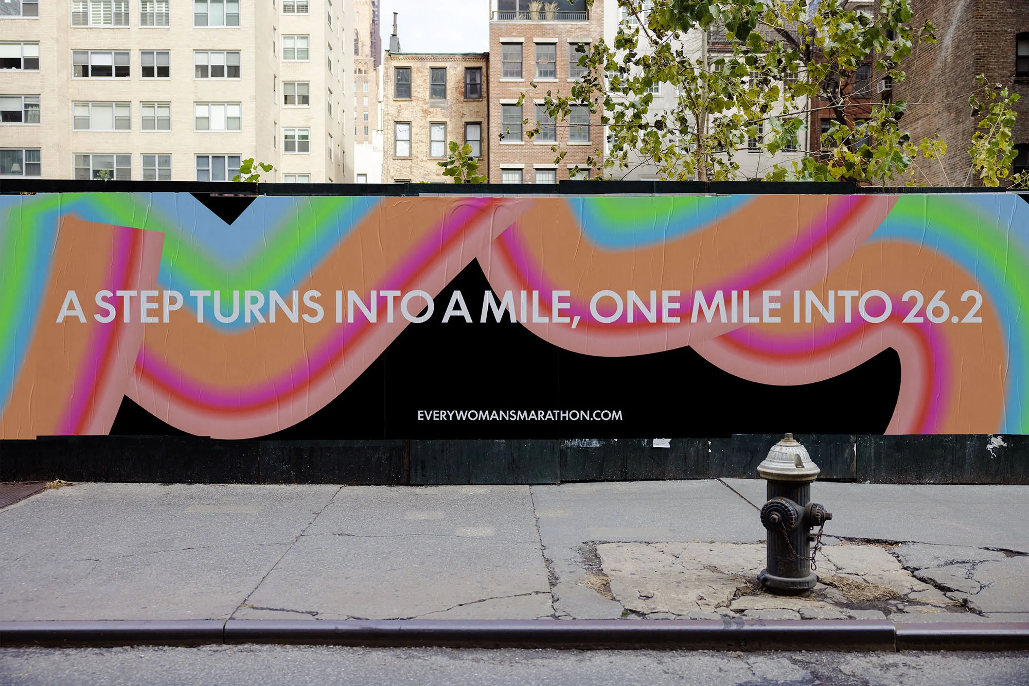 Outdoor advertisement featuring an inspirational running message with colorful graphics on a building facade in an urban environment.