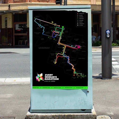 Outdoor advertising on a utility box features a colorful marathon map of Savannah, Georgia, promoting the annual Every Woman's Marathon.