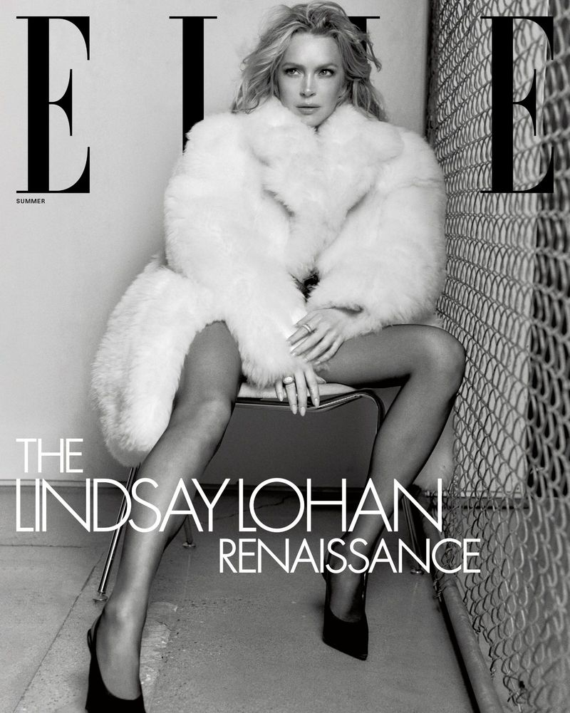 Elle magazine cover featuring a model sitting on a chair wearing a large white fur coat and black high heels, with a metal fence backdrop.