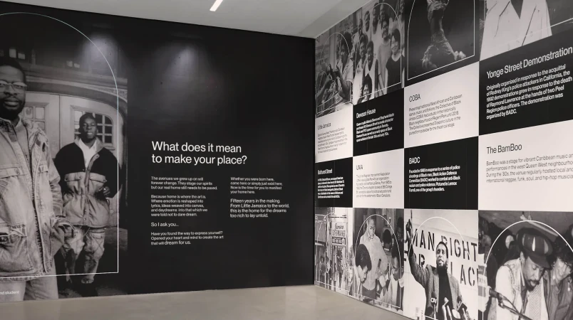 Black and white photo of a wall with pictures of Black people and text about them, including quotes about making your place.