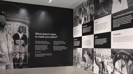 Exhibition wall featuring black and white archival photographs, typography, and historical panels for Nia Centre brand identity.