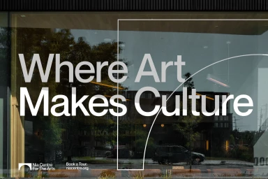 Large white typography on a glass building facade reading Where Art Makes Culture with graphic line elements