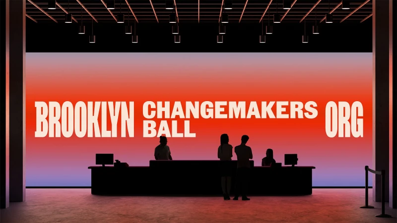 Indoor event space features silhouetted figures in front of a vibrant gradient backdrop displaying 'Brooklyn Changemakers Ball'.